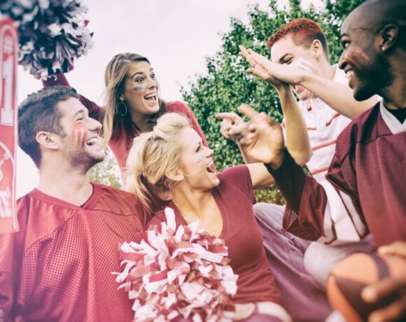 people cheering for the same sports team wearing maroon